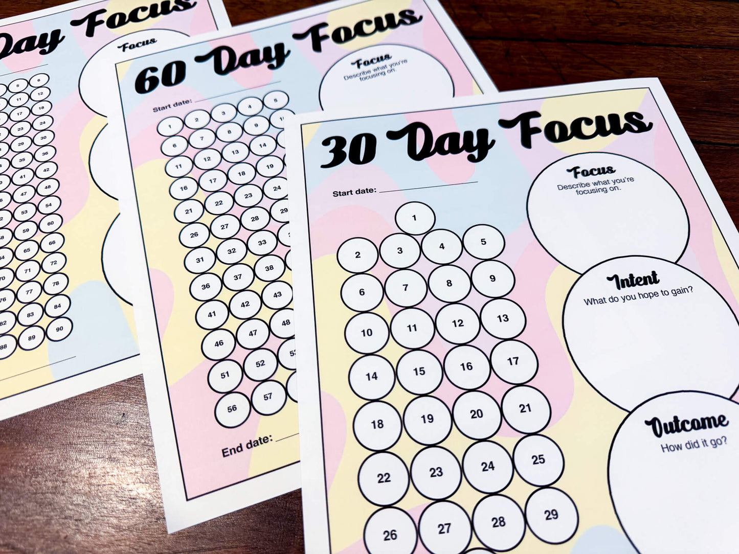A 30, 60, and 90 Day Focus Worksheet for tracking daily goals, challenges, habits, and more. Each sheet has a space for writing down your focus, intent, and outcome. There are circles you can fill in or cross off each day to indicate you completed your daily focus goal.